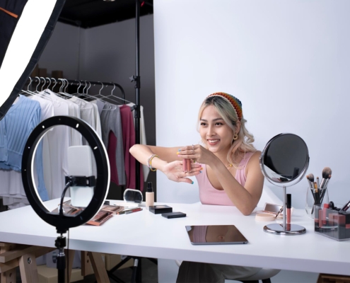 Front view of a beauty vlogger showing products to camera