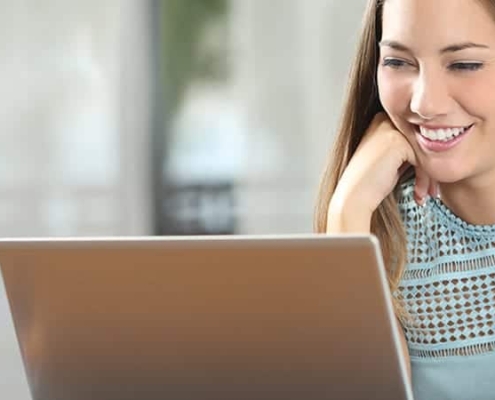 Catalog lady smiling at computer with paper