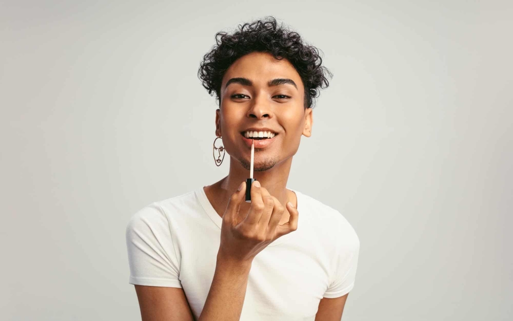 Image of a person applying lip gloss.