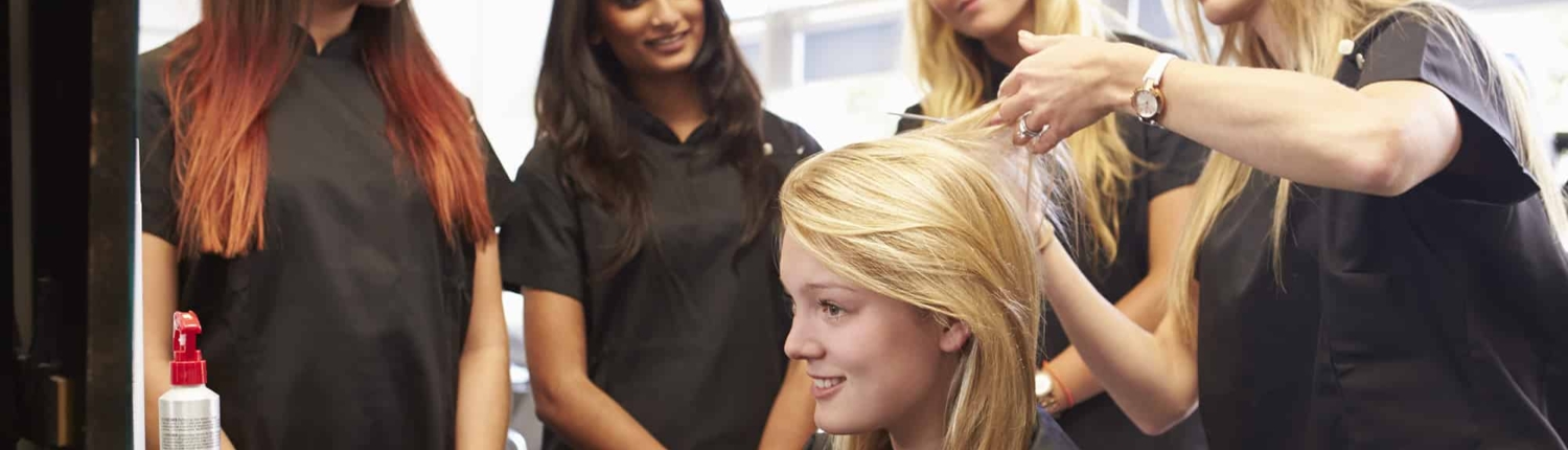Woman Showing Other Hairdressers How to Cut Hair