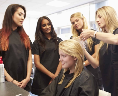 Woman Showing Other Hairdressers How to Cut Hair