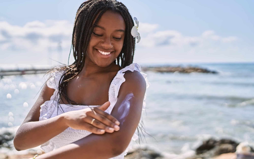 Person at beach putting on sun lotion