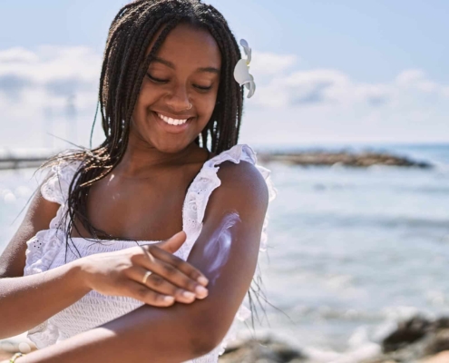 Person at beach putting on sun lotion