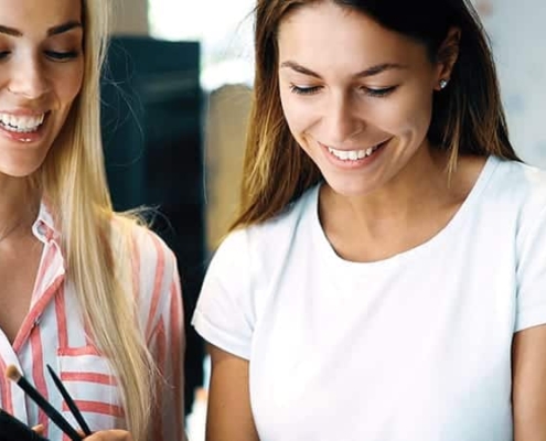 Success Stories ladies smiling down at book