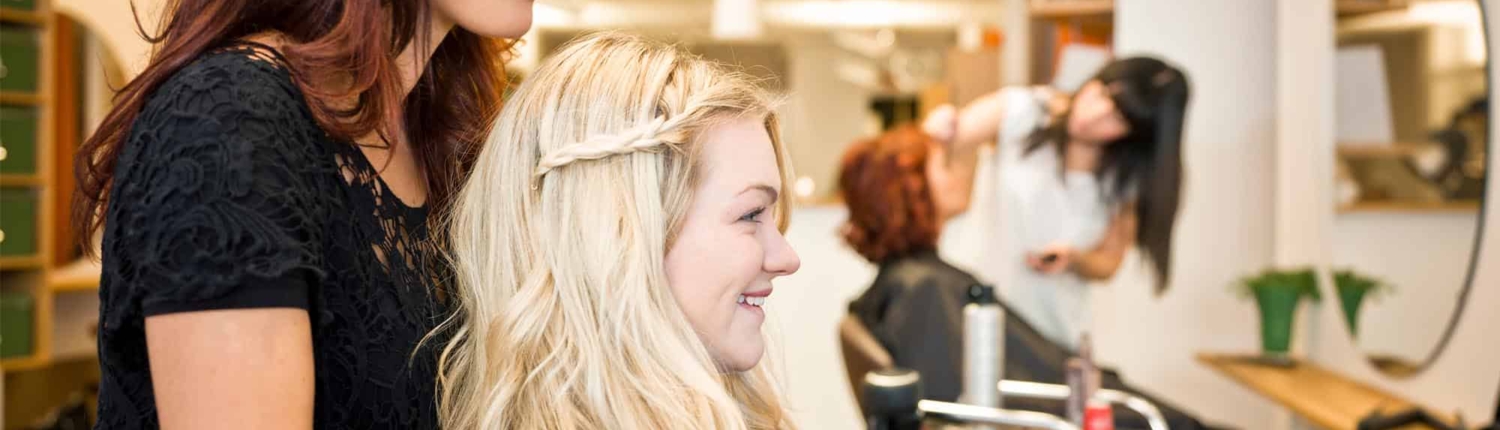cosmetologist showing client her hair cut
