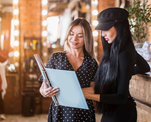 female administrator of beauty and hair salon with a smile shows portfolio