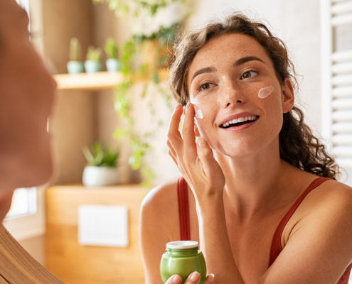 Woman Applying Moisturiser On Face During Morning Routine