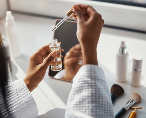 Young Woman Holding Bottle Of Vitamin Face Serum